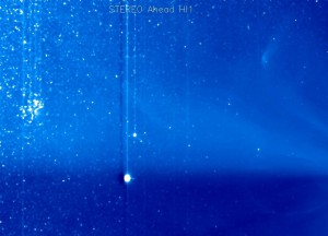 Auch nach Verlassen von LASCO C3 weiter unter Beobachtung: der Überrest von ISON am Abend des 1. Dezember rechts im Gesichtsfeld der Kamera HI1 des Satelliten STEREO A – man beachte den Merope-Nebel der Plejaden zum Vergleich der Flächenhelligkeit. In der Mitte unten die Erde und oben der Merkur, das Helligkeitsmuster im Hintergrund ist ein Koronaler Massenauswurf. [SECCHI]