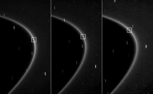 Drei Cassini-Aufnahmen von 27. Oktober 2008 durch verschiedene Filter zeigen, wie sich innerhalb eines hellen Bogens des G-Rings Saturns ein winziger Mond entlang bewegt; durch die jeweils 46 Sekunden Belichtungszeit sind Mond wie Sterne Strichspuren. [NASA/JPL/Space Science Institute]